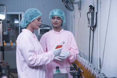 Güney Asyalı kadın fabrika işçisi veya kadın uzman personel içki kuyruğuna bakıyor