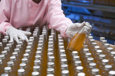 Güney Asyalı kadın fabrika işçisi veya kadın uzman personel içki kuyruğuna bakıyor