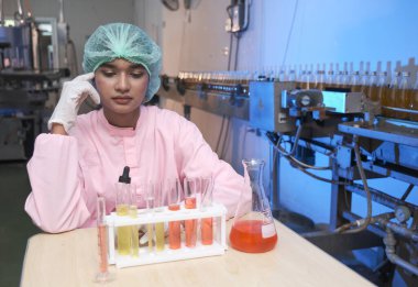 Güney Asyalı kadın laboratuvar asistanı veya kadın uzman kadrosu fabrikada veya laboratuarda test sıvısıdır