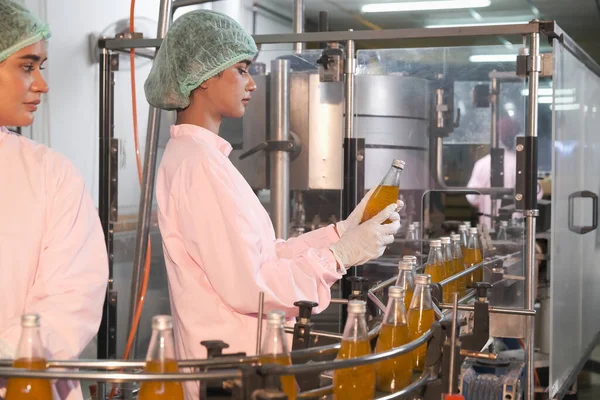 Güney Asyalı kadın fabrika işçisi veya kadın uzman personel içki kuyruğuna bakıyor