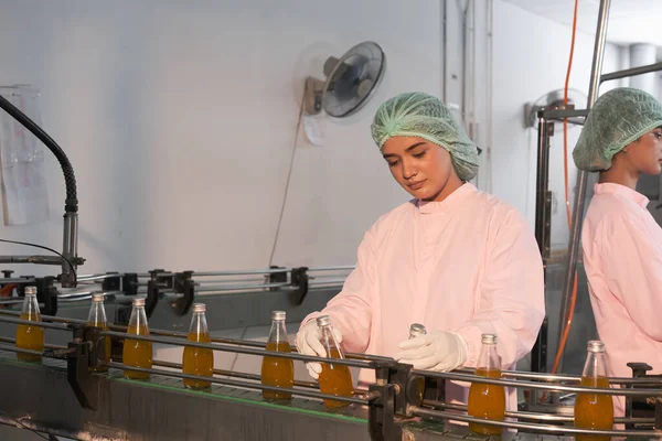 south Asia woman factory worker or woman expert quality staff is checking bottles line for beverage