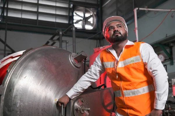 South asia male factory worker or Man engineer or expert staff wear safety vest and helmet of maintenance and checking steam boiler