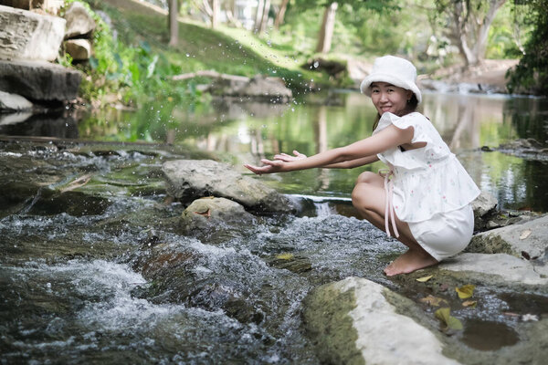 портрет азиатская женщина расслабиться в тропической природе рядом с потоком