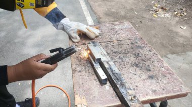 Endüstriyel teknisyende elleri kaynak yapıyor.