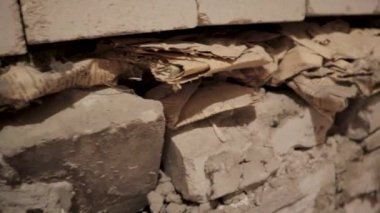 Bir yıkım sahnesinin yüksek çözünürlüklü yakın çekim videosuyla projelerinize özgün kum dokusu ve çürüme hissi ekleyin. Görüntülerde neredeyse yıkılmış tuğla bir duvar var.