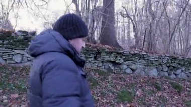 Bu yüksek çözünürlüklü video ile sonbahar projelerinizi geliştirin. Çok eski bir taş duvar boyunca huzur içinde yürüyen bir adamı gösterin. Bu kısa, 5-20 saniyelik klip huzurlu ve tarihsel açıdan zengin bir film yaratıyor.