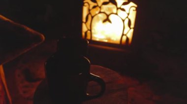 Bu yüksek çözünürlüklü videoyla projelerinizde sıcak ve davetkar bir atmosfer yaratın. Görüntülerde iki kupa çay var. Kırsal bir ağacın üzerinde, süslü bir alçıda çatırdayan bir ateşin yanında.