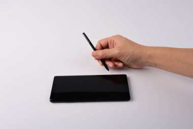 Beyaz arkaplana izole edilmiş yazmak için elinde kalem, akıllı telefon ve siyah stil. 