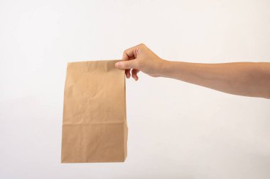 Beyaz arka planda el ve kahverengi kese kağıtları.