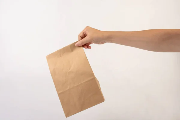Hand and brown paper bags on white background.