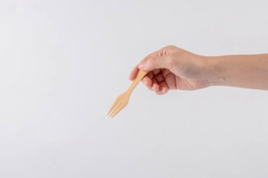 Hand and wood fork on white background.