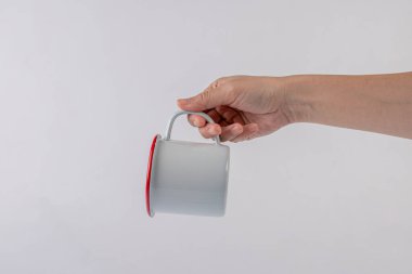 Hand and white ceramic cup on white background