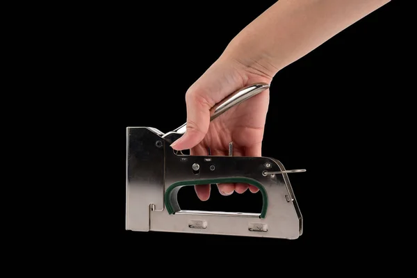 Stapler Pliers and a hand on a black background