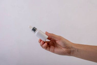 Beyaz arka planda el ve beyaz cam damlalar. 