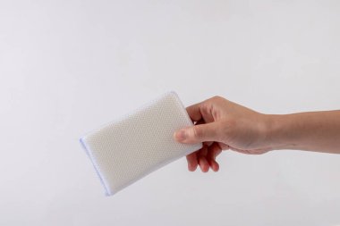 Beyaz bir siyah zeminde bulaşık yıkamak için beyaz bir sünger..