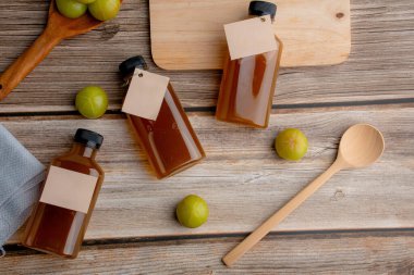 Closeup pile of fresh green Amla or Indian gooseberry fruits (phyllanthus emblica) with Gooseberry Juice, healthy diet on wood table.