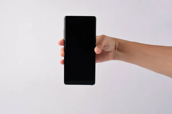 Beyaz arkaplana izole edilmiş yazmak için elinde kalem, akıllı telefon ve siyah stil. 