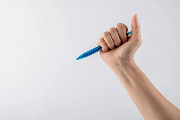 Close-up of a woman\'s hand holding a pen and writing gesture isolated on a white background