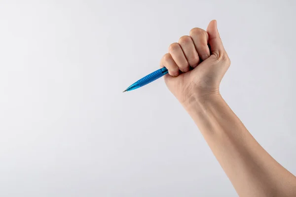 Close-up of a woman\'s hand holding a pen and writing gesture isolated on a white background