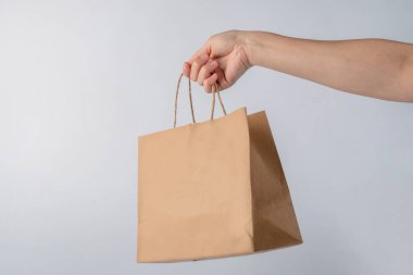Beyaz arka plan üzerinde izole kese kağıdı tutan el.