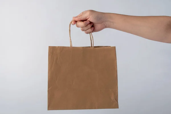 stock image Hand Holding Paper Bag isolated on white background.