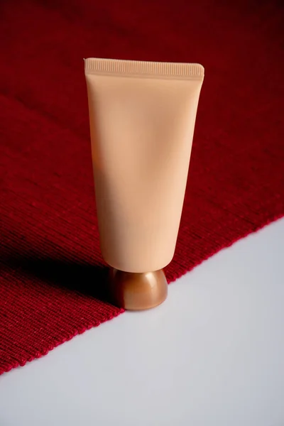 白色和红色背景的管状 乳液或血清中的化妆品 — 图库照片