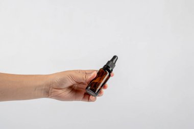 Beyaz arka planda koyu kehribar camından yapılmış el ve kozmetik şişeleri..