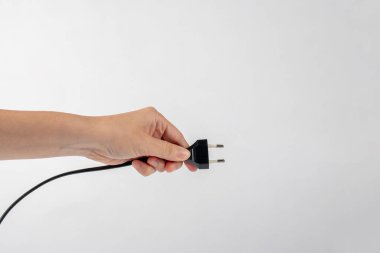 Beyaz arka planda elektrik prizi. Beyaz arkaplanda izole edilmiş tıpası olan el.