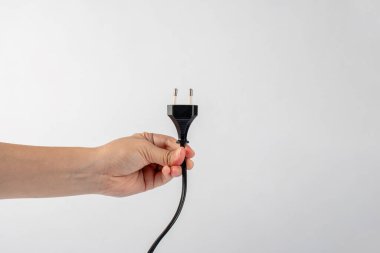 Beyaz arka planda elektrik prizi. Beyaz arkaplanda izole edilmiş tıpası olan el.