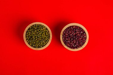 Kırmızı arka planda sepetin içinde fasulye ve fasulye.