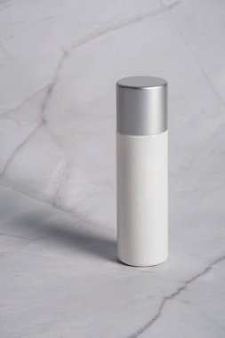 Krem veya losyon için plastik beyaz tüp. Gri beton arka planda cilt bakımı veya güneş kremi kozmetiği.