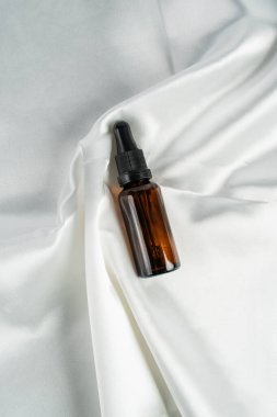 Parlak arka planda koyu kehribar camından yapılmış kozmetik şişeleri.