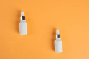 Krem arka planda tüp, şişe, losyon veya serum gibi kozmetik ürünler. 