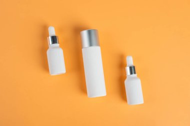 Krem arka planda tüp, şişe, losyon veya serum gibi kozmetik ürünler. 