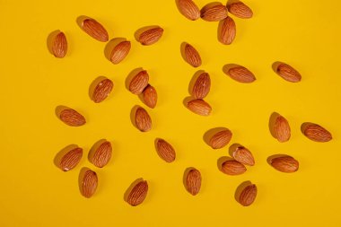 Sarı arkaplanda badem tohumu