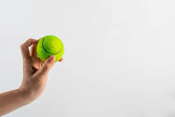 Tennis ball in hand on white background (with clipping path)