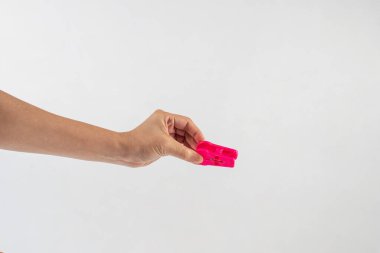 Beyaz arka planda elde asılı giysileri kapat