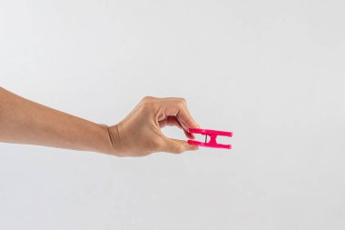 Beyaz arka planda elde asılı giysileri kapat