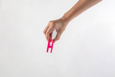 Beyaz arka planda elde asılı giysileri kapat