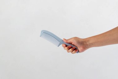 Yeni mavi saç tarağı ve el beyaza izole edilmiş..