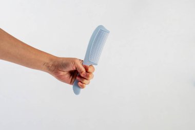 Yeni mavi saç tarağı ve el beyaza izole edilmiş..