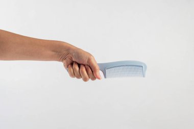 Yeni mavi saç tarağı ve el beyaza izole edilmiş..