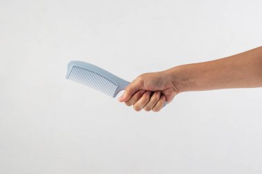Yeni mavi saç tarağı ve el beyaza izole edilmiş..