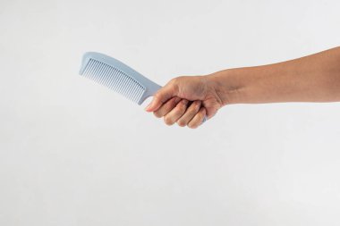 Yeni mavi saç tarağı ve el beyaza izole edilmiş..