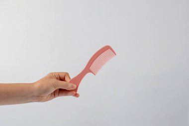 Eldeki tarak beyaz arkaplanda izole edilmiş.