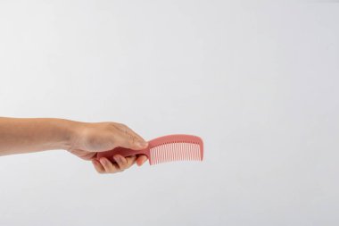 Eldeki tarak beyaz arkaplanda izole edilmiş.