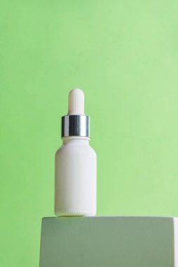 Krem veya losyon için plastik beyaz tüp. Yeşil arka planda şık dekorları olan cilt bakımı veya güneş kremi kozmetiği.