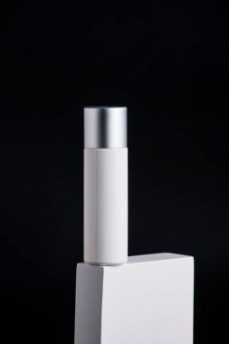 Krem veya losyon için plastik beyaz tüp. Cilt bakımı ya da güneş kremi kozmetik ürünleri siyah arka planda şık dekorlar.