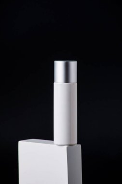 Krem veya losyon için plastik beyaz tüp. Cilt bakımı ya da güneş kremi kozmetik ürünleri siyah arka planda şık dekorlar.