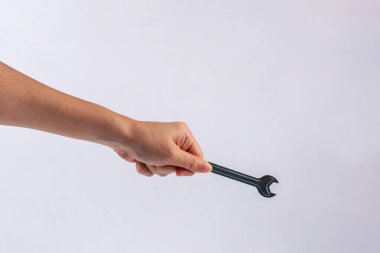 Beyaz arka plan üzerinde izole bir İngiliz anahtarı tutan el.